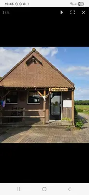a building with a cross in front of it at De indiaan in Noord-Scharwoude