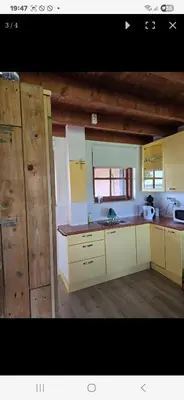 a kitchen with white cabinets and a sink at De indiaan in Noord-Scharwoude