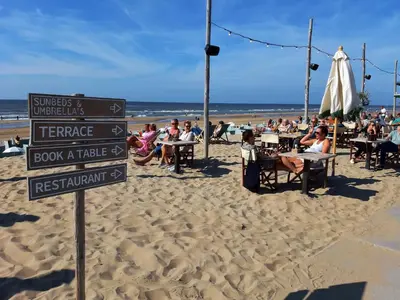 a group of people sitting at tables on the beach at Motor Yacht Amstelle in Amsterdam