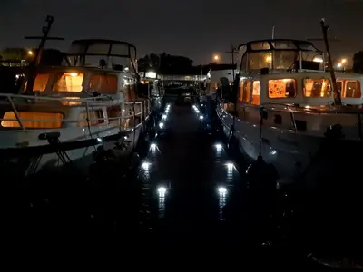 two boats are docked in a marina at night at Motor Yacht Amstelle in Amsterdam