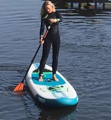 a woman standing on a paddle board in the water at Motor Yacht Amstelle in Amsterdam