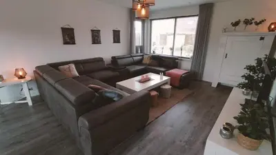 a living room with a couch and a table at Vakantiehuis Horsterwold in Zeewolde