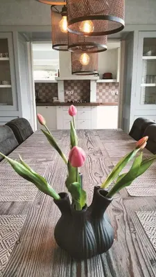 a black vase with flowers in it sitting on a table at Vakantiehuis Horsterwold in Zeewolde