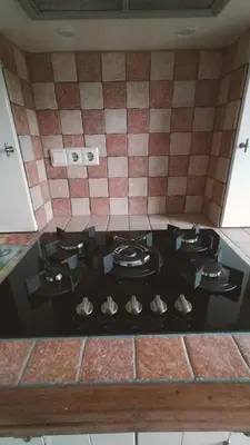 a stove top in a kitchen with a tiled wall at Vakantiehuis Horsterwold in Zeewolde