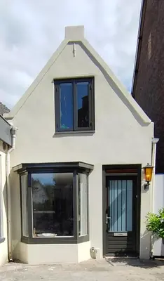 a white house with black windows at Cosy Tiny House 5 min walk Keukenhof included entrance keukenhof in Lisse