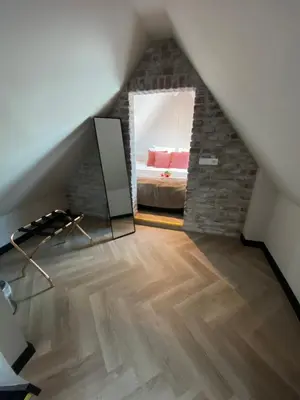 a attic room with a mirror and a bed at Harbour Suites Boutique Hotel in Monnickendam