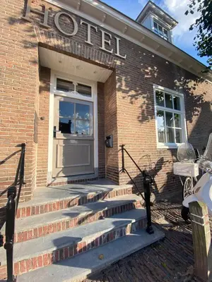 a door to a brick building with stairs in front at Harbour Suites Boutique Hotel in Monnickendam