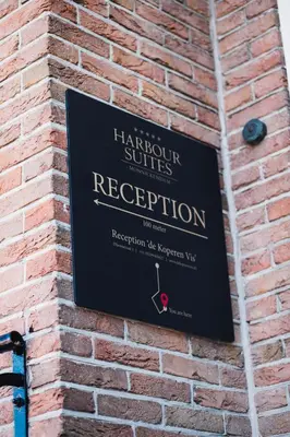 a sign on the side of a brick building at Harbour Suites Boutique Hotel in Monnickendam