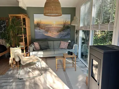a living room with a couch and a table at Lodge 'De Groene Parel' in Schoorl
