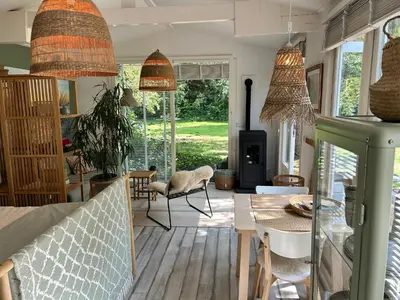 a living room with pendant lights and a couch at Lodge 'De Groene Parel' in Schoorl