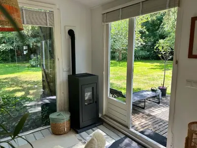 a screened in porch with a wood burning stove at Lodge 'De Groene Parel' in Schoorl