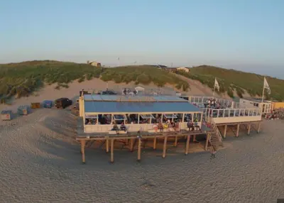 a pier on a beach with a restaurant on it at Lodge 'De Groene Parel' in Schoorl