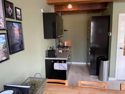 a kitchen with a black refrigerator and a sink at Het Schaager Waapen in Alkmaar