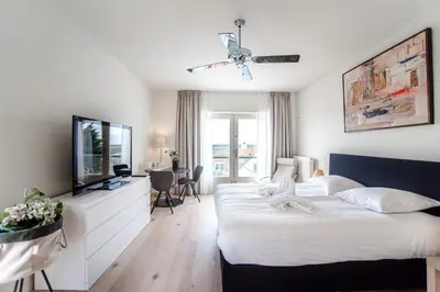 a bedroom with a large bed and a television at Keller Beach in Zandvoort