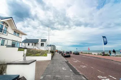 a road with cars parked on the side of a beach at Keller Beach in Zandvoort