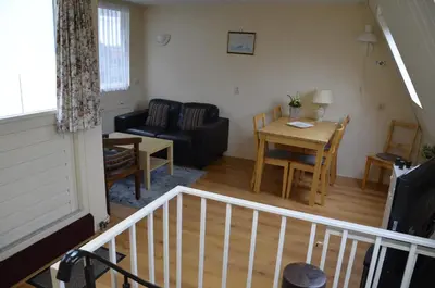 a living room with a couch and a table at Zomerhuisje achter Torenlicht in Egmond aan Zee