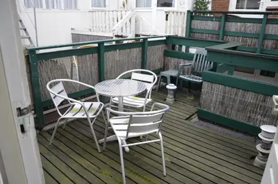 a table and chairs sitting on a deck at Zomerhuisje achter Torenlicht in Egmond aan Zee