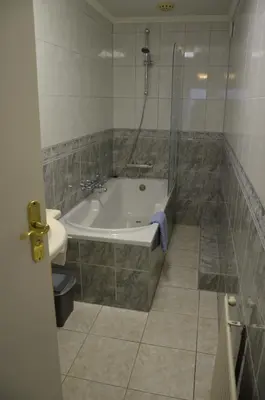 a bathroom with a tub and a shower and a sink at Zomerhuisje achter Torenlicht in Egmond aan Zee