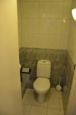a bathroom with a toilet in a tiled room at Zomerhuisje achter Torenlicht in Egmond aan Zee