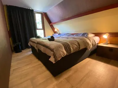 a bedroom with a bed and a window at Uniek vakantiehuisje in rustige en groene omgeving in Nieuwe-Niedorp