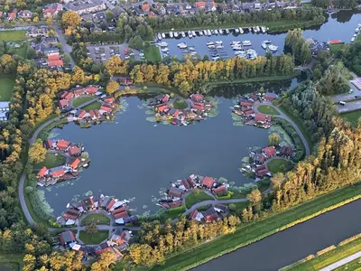 an aerial view of a park with a lake at Uniek vakantiehuisje in rustige en groene omgeving in Nieuwe-Niedorp