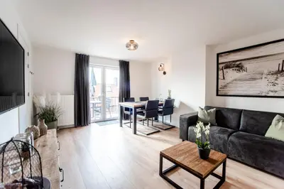 a living room with a couch and a table at Seawave Apartment in Zandvoort