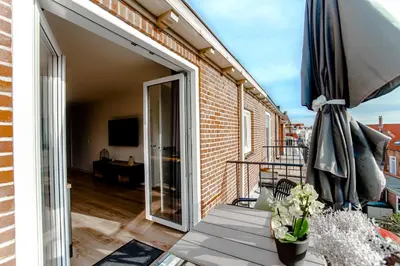 a balcony with a sliding glass door to a patio at Seawave Apartment in Zandvoort
