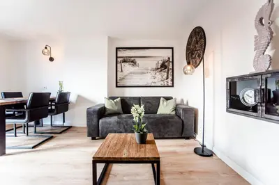 a living room with a couch and a table at Seawave Apartment in Zandvoort