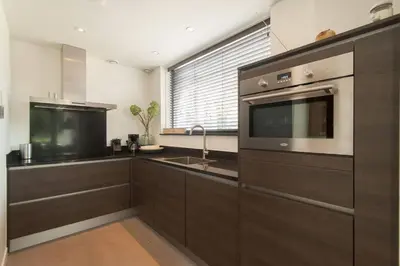 a kitchen with a sink and a microwave at Villa Klein Geluk in Egmond aan Zee