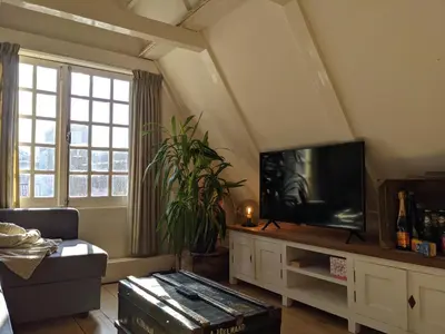 a living room with a flat screen tv on a cabinet at StoreStay DamSquare in Amsterdam