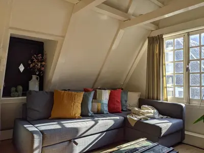 a living room with a blue couch with colorful pillows at StoreStay DamSquare in Amsterdam