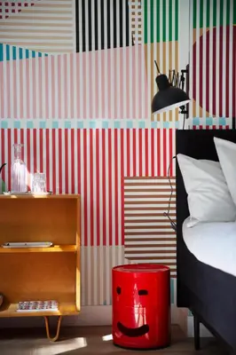a bedroom with a red trash can next to a bed at MUZE Hotel Utrecht in Utrecht