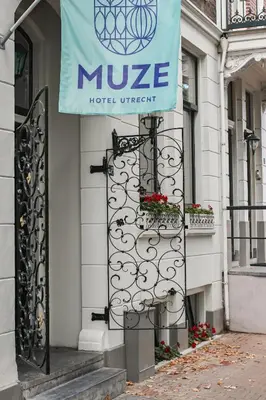 a hotel entrance with a sign on a building at MUZE Hotel Utrecht in Utrecht