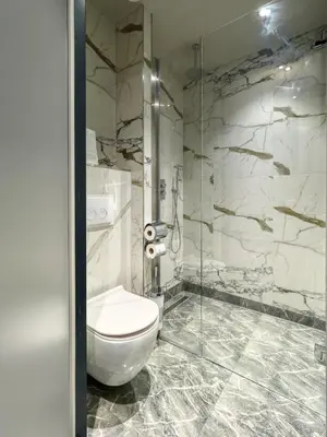 a bathroom with a toilet and a glass shower at Triple G Hotels in Amsterdam