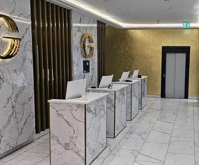 a row of tables with laptops on them in a lobby at Triple G Hotels in Amsterdam