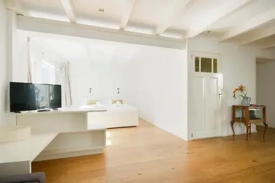 a white room with a bed and a window at Green Alley Studio in Amsterdam
