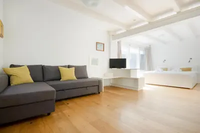 a living room with a couch and a television at Green Alley Studio in Amsterdam