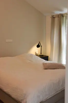 a bedroom with a white bed and a window at In de bocht in Heiloo