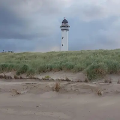 a lighthouse sitting on top of a grass covered field at In de bocht in Heiloo