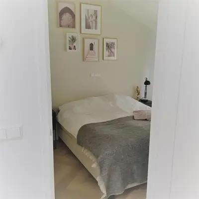 a bedroom with a bed and some pictures on the wall at In de bocht in Heiloo