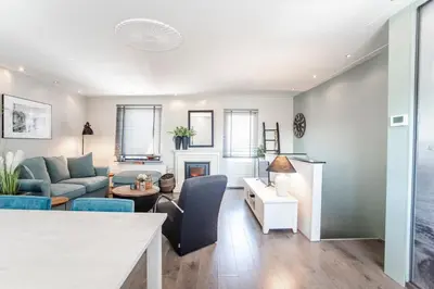a living room with a couch and a table at Het Zomerhuis Family apartment in Zandvoort
