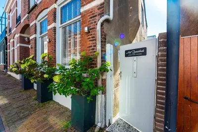 a building with potted plants on the side of a street at Het Zomerhuis Family apartment in Zandvoort