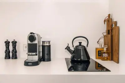 a kitchen counter with a coffee maker and a tea kettle at The Pine Tree House in Zandvoort