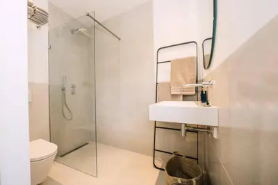 a bathroom with a shower and a sink and a toilet at The Pine Tree House in Zandvoort