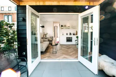 an open door to a living room with a kitchen at The Pine Tree House in Zandvoort