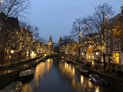 a canal with boats in a city at night at KG House in Amsterdam