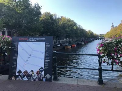 a sign on the side of a river with a map at KG House in Amsterdam