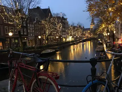 a couple of bikes parked next to a canal at night at KG House in Amsterdam