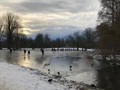 a group of people ice skating on a frozen pond at KG House in Amsterdam