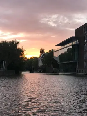 a view of a river at sunset with buildings at Six in Amsterdam